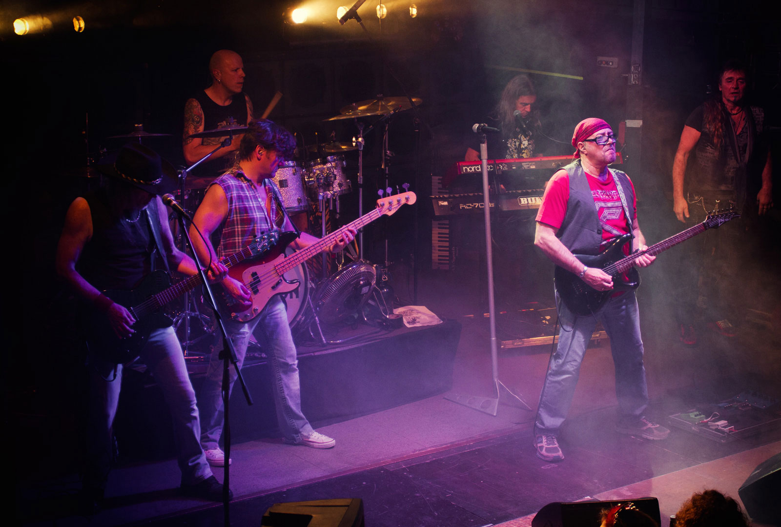 Gitarrist Giorgio Camese beim Gitarrensolo mit der Band im Hintergrund.